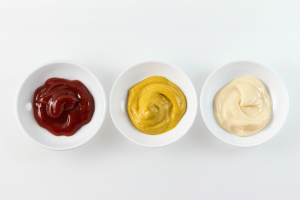 Alimentos que prejudicam seu corpo potes com molhos de ketchup, mostarda e maionese